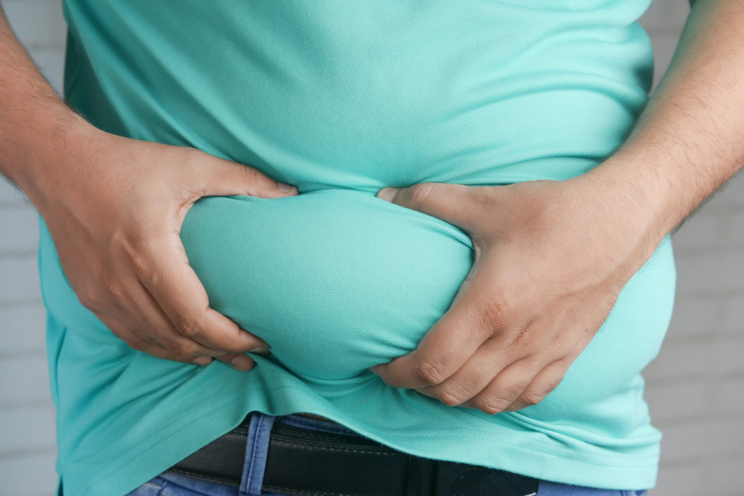 a man pinching inches from his stomach